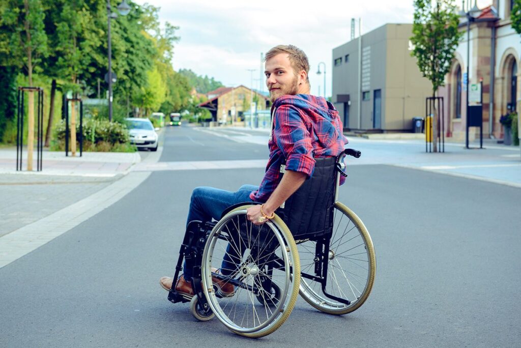 Disabled Man In Wheelchair On Road